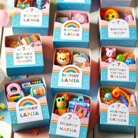 Personalisierte- Partygeschenk-Boxen- für- eine -Geburtstagsfeier -eines- 7-Jährigen, jede- Box- einzigartig -dekoriert- und- gefüllt- mit -altersgerechten- Spielzeugen- und -Leckereien